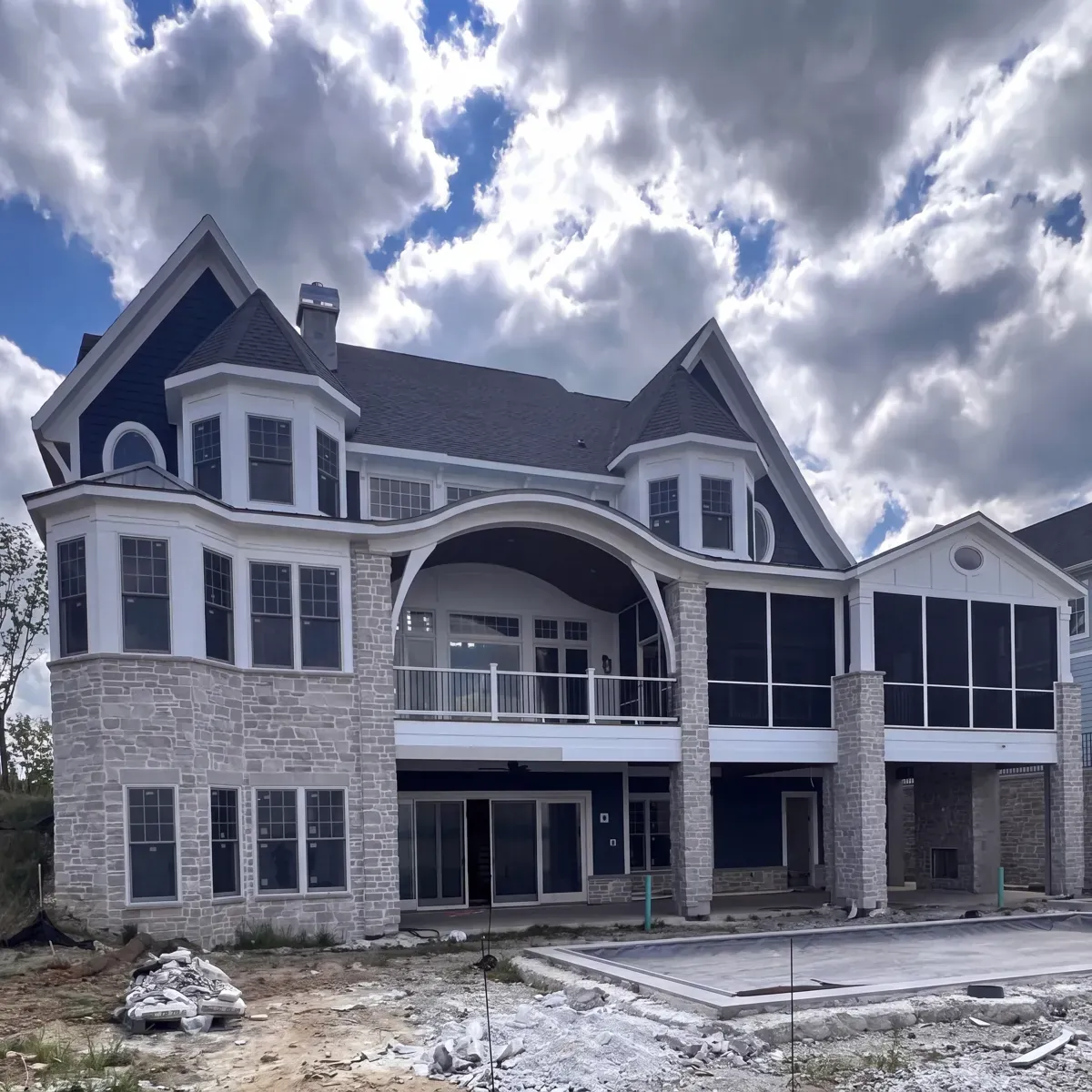 Stone home with a completed shingle roof by GNG Roofing and Construction