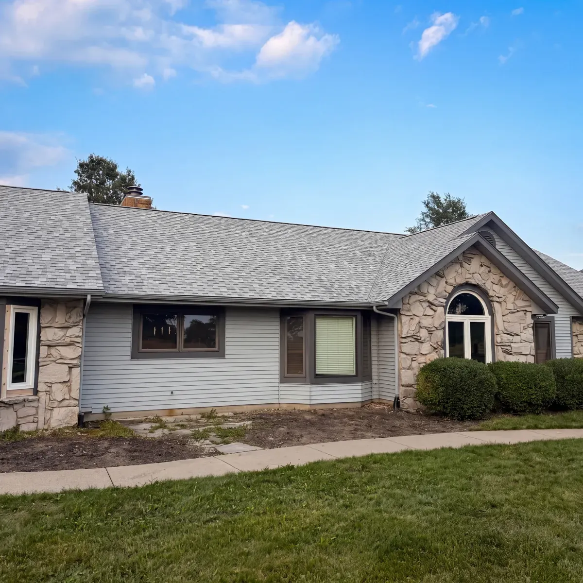 Stone ranch home roofline photographed at dusk after completion